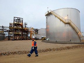 An oilfield worker walks past an oilsands facility in Alberta.