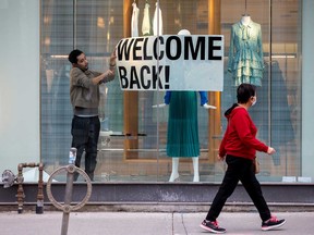 An employee at Zara puts up a sign during a phased reopening from the coronavirus disease restrictions in Toronto, Ontario, on May 19.
