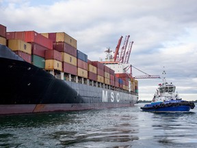 A tugboat helps a cargo ship dock at the Port of Montreal.