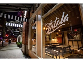 A woman walks past a closed restaurant in a quiet downtown, amid concerns about the spread of COVID-19, in Vancouver, on Tuesday, March 17, 2020. Vancouver city council is also preparing to debate the issue of making more room for restaurants and Mayor Kennedy Stewart has said the city must think creatively to help spur recovery.