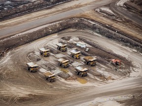 Heavy haulers sit parked at the Suncor Energy Inc. Millennium mine in this aerial photograph taken above the Athabasca oilsands near Fort McMurray, Alberta, in 2018.