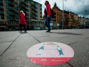 A big sticker of the healthcare services of Sweden is placed on a pavement in the heart of Stockholm to instruct people to follow the 2 meters rule to reduce the risk of getting sick on May 4, 2020.