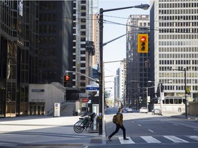 A pedestrian crosses Bay Street in Toronto's financial district.