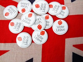 Vote Leave badges sit displayed on a Union Jack flag during the 2016 Brexit campaign.