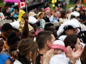 Rachel Gbita, who earned her citizenship with her family, waves a flag at a citizenship ceremony during Canada Day celebrations at the Alberta Legislature in Edmonton, on Monday, July 1, 2019.  Canada will likely see fewer immigrants this year due to the pandemic.