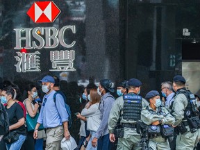 Riot police stand guard in front of an HSBC Holdings Plc bank branch in the Central district ahead of an anticipated lunchtime protest in Hong Kong, China, on Friday, May 29, 2020.