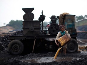 A boy works at a coal depot in India.
