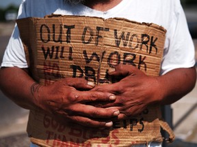 George, who is homeless, panhandles along a street in Lawrence on August 16, 2019 in Lawrence, Massachusetts.