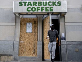 customer wearing a protective mask exits a boarded up Starbucks Corp. location in Washington, D.C., U.S., on Thursday, June 4.