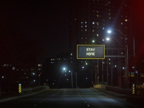 "Stay Home" is displayed on a sign over an empty road in Toronto, Ontario, Canada, on Wednesday, March 25, 2020.