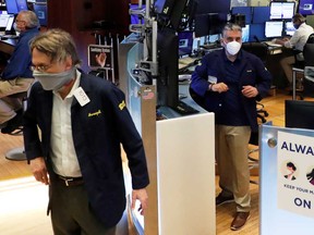 Traders wear masks as they work on the floor of the New York Stock Exchange as the outbreak of the coronavirus disease (COVID-19) continues in New York.