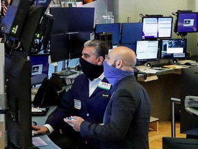 Traders wearing masks work on the floor at the New York Stock Exchange.