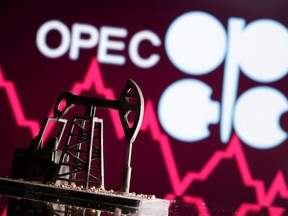A 3D printed oil pump jack is seen in front of displayed stock graph and Opec logo in this illustration picture.