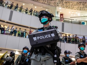 A riot police officer (C) stands guard during a clearance operation during a demonstration in a mall in Hong Kong on July 6, 2020, in response to a new national security law introduced in the city which makes political views, slogans and signs advocating Hong Kongs independence or liberation illegal.