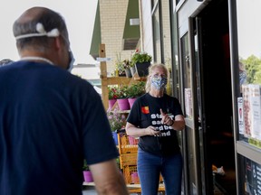 A worker wearing a protective mask manages store capacity at a Loblaws store in Ottawa.