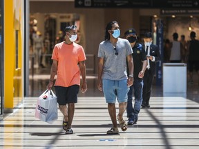 Ash Nathwan (left) and Andrew Singh wear masks while shopping at CF Sherway Gardens in Toronto earlier this month.