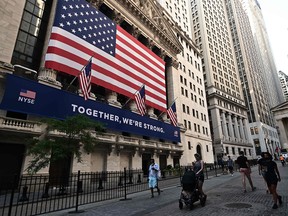 People walk outside the New York Stock Exchange (NYSE) on July 13, 2020 at Wall Street in New York City.