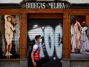 A man walks past a closed bar in Madrid, Spain.