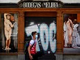 A man walks past a closed bar in Madrid, Spain.