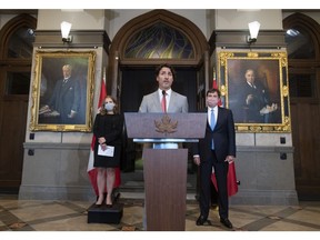 Deputy Prime Minister and Minister of Finance Chrystia Freeland and President of the Queen's Privy Council for Canada and Minister of Intergovernmental Affairs Dominic LeBlanc look on as Prime Minister Justin Trudeau speaks during a news conference on parliament hill in Ottawa, Tuesday, Aug. 18, 2020.