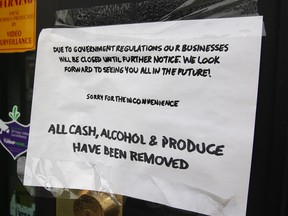 A sign on the front of a closed business in Calgary in May.