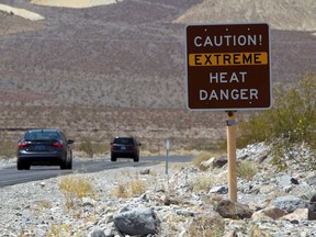 A sign warns of extreme heat as tourists enter Death Valley National Park in California.