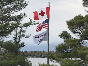 Three flags fly over Treasure Island, testimony to American’s deep roots Pointe au Baril.
