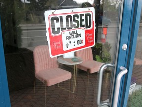 A Closed sign is taped to the door of a salon in Calgary.