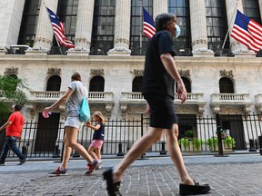 People walk by the New York Stock Exchange in August.