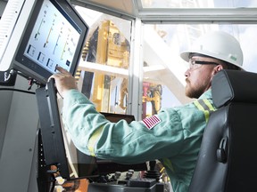 A Precision Drilling tech worker examines drilling data at the Houston Technical Service Center.
