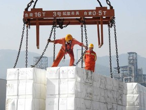 Workers load products for export onto a ship at the port in Lianyungang, in China's eastern Jiangsu province.