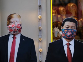 Cardboard cutouts, displaying images of U.S. President Donald Trump and Chinese President Xi Jinping, with protective masks near a gift shop in Moscow, Russia.
