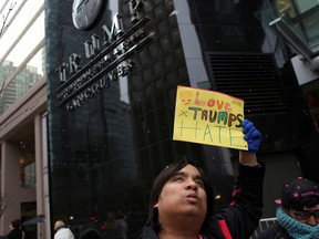 A protester holds a sign during the grand opening of the Trump International Hotel and Tower in Vancouver, February 28, 2017.