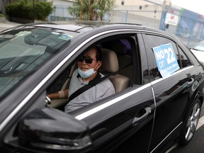 Rideshare driver Peter Hong joins a car caravan at a protest by Uber and Lyft drivers against the upcoming California Proposition 22 ballot measure, which would exempt rideshare companies from classifying their drivers as employees, in Los Angeles in August.