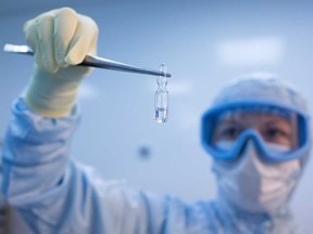 A worker shows an ampoule containing a component of the 'Gam-COVID-Vac' COVID-19 vaccine, Russia’s first registered vaccine.