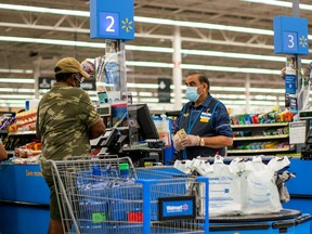 A worker and a shopper are seen wearing masks at a Walmart store, in North Brunswick, New Jersey.