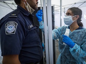 A medical worker administers a rapid COVID-19 test to a U.S Customs and Border Protection agent at San Francisco International Airport (SFO) in San Francisco, California, on Thursday, Aug. 27, 2020.