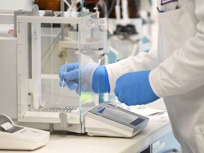 A chemist works at AstraZeneca's headquarters. The company has paused global trials of its   experimental coronavirus vaccine.