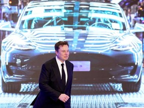 Tesla Inc CEO Elon Musk walks next to a screen showing an image of Tesla Model 3 car earlier this year in Shanghai, China. Musk has promised to cut cobalt out of batteries, something analysts say is likely to happen soon.