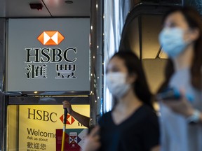 Pedestrians wearing protective masks walk past a HSBC Holdings Plc branch in Hong Kong on Sept. 21, 2020.