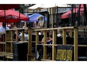 A server wears a mask as she works among the plexiglass dividers at a bar's outdoor patio in the Byward Market in Ottawa, on July 12, 2020, in the midst of the COVID-19 pandemic. As the weather gets cooler and COVID-19 cases start to surge again, more and more Canadians are looking to extend patio season by adding a heater to their outdoor space.The demand for patio heaters has risen so much that retailers have been struggling to keep them in stock, according to the Retail Council Canada. Moves multiple wires; guard against duplication.