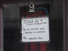 A sign in a barber shop window indicated the establishment was closed because of COVID-19 in Ottawa, Wednesday, March 18, 2020. A new poll suggests that there are people in this country who believe that warnings from public officials about the threat of COVID-19 are overblown, but also that many expect the country to return to some form of lockdown.