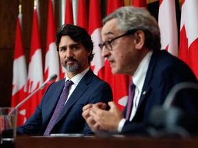 Prime Minister Justin Trudeau, right, listens while Michael Sabia, chairman of the Canada Infrastructure Bank, speaks during a news conference on Thursday.