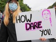 A protester holds a banner with the image of Swedish climate activist Greta Thunberg and the writing 'How dare you!' as climate activists gather on a "Global Day of Action" organized by the 'Fridays for Future' climate change movement during the coronavirus pandemic on September 25, 2020 in Berlin, Germany.