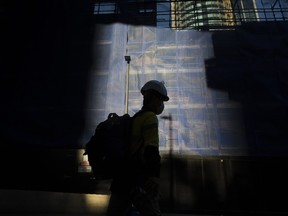 construction worker walks past a construction site in Sydney, Australia, on Tuesday, Oct. 13, 2020. Australia last week released a fiscal blueprint that pushes debt and deficit to a peacetime record.