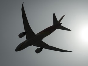 A plane is silhouetted as it takes off from Vancouver International Airport in Richmond, B.C.