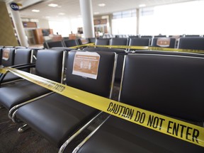 Seats in the waiting area of domestic departures lounge of Calgary International Airport are seen with caution tape on them on June 9, 2020. The Alberta government says rapid COVID-19 tests will soon be available at the Calgary airport and a United States border crossing so travellers coming into Canada don't have to quarantine for a full 14 days.