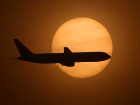 A cargo plane on its final approach into Long Beach Airport passes in front a hazy sun caused by smoke from a wildfire that covered 4,000 acres and forced the evacuations of 60,000 residents.