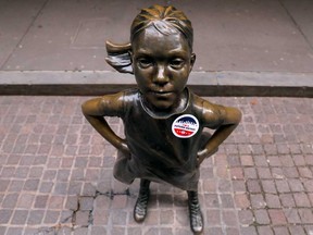 "I'm a Future Voter" sticker is seen on The Fearless Girl statue stands outside the New York Stock Exchange. Stocks are soaring today in a global risk-asset rally.