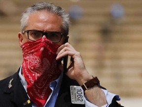 A masked trader walks by the New York Stock Exchange on the first day that traders are allowed back in May. Investors and non-investors alike are more than ready to put this year behind them.